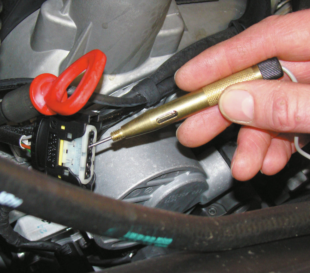 KL-0190-30 - Lámpara de prueba: Mano sujeta lámpara de prueba con punta en conector eléctrico del motor