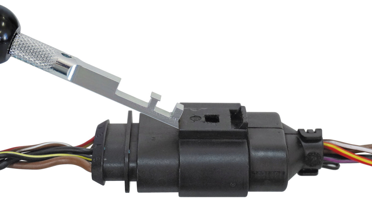 KL-0190-13 - Herramienta de desbloqueo compacta: Herramienta metálica extrayendo un conector eléctrico