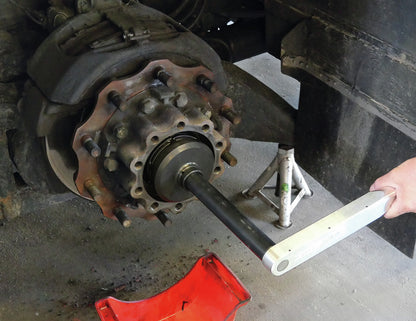 KL-1020-42 - Tuerca de bloqueo, ZF-Axle, Ø 122,5mm: Herramienta insertada en cubo de rueda con eje sobre vehículo elevado